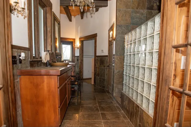 a view of a room with kitchen island stainless steel appliances wooden floor and chandelier