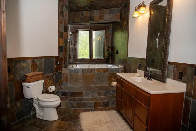 a bathroom with a toilet a sink and a window