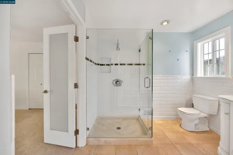 a bathroom with a glass shower door and a toilet