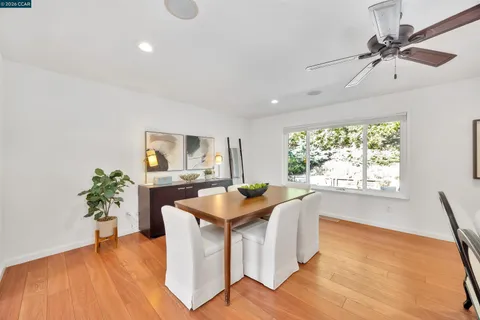 a dining room with furniture potted plants and wooden floor