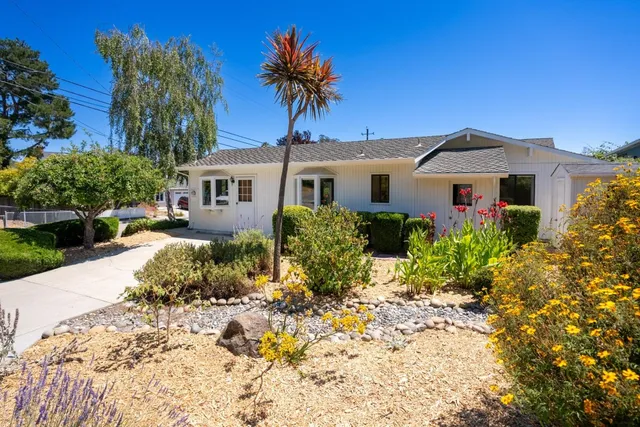 a front view of a house with a garden