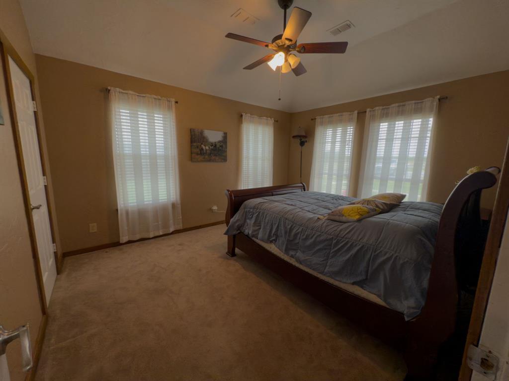 2931 Wall Street Road Howe, TX 75459 - Photo 27 of 38 a spacious bedroom with a bed and a chandelier
