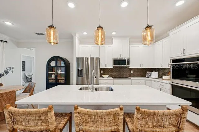 a kitchen with kitchen island granite countertop a stove a sink a counter top space and cabinets