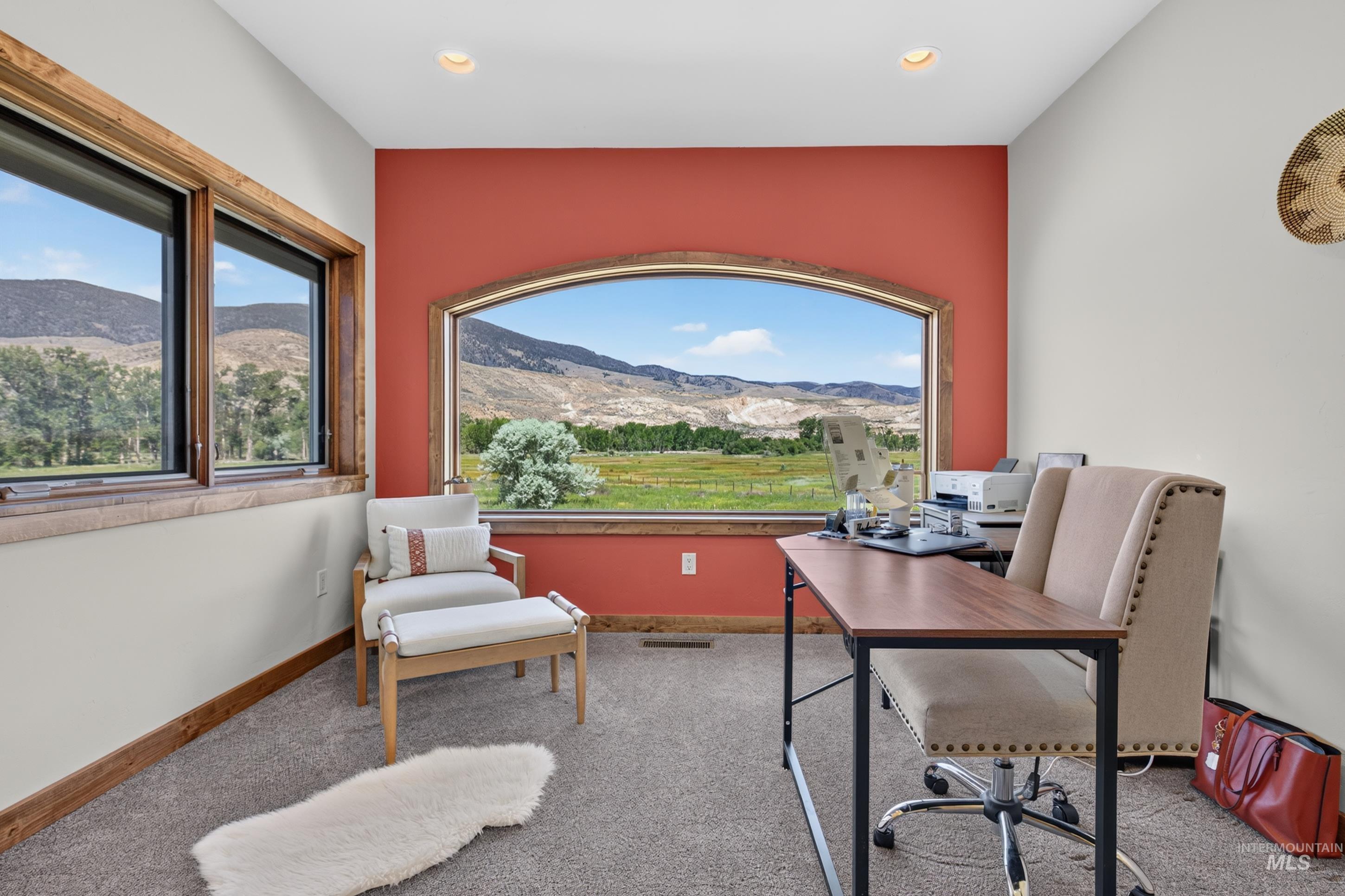 63 Mountain View Road Salmon, ID 83467 - Photo 25 of 50 Spacious room featuring an arched picture window with mountain and field scenery, two additional windows with wood-finish trim, a recessed ceiling light, and neutral-toned carpeting