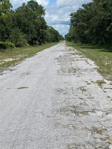 a sign of golf club on a wall under a tree