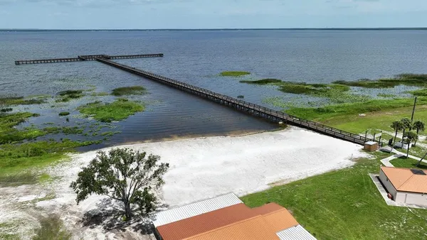 a kitchen with stainless steel appliances kitchen island granite countertop a table chairs and a refrigerator
