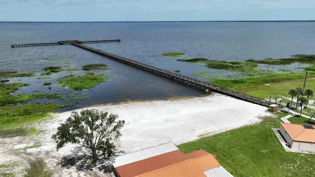 a kitchen with stainless steel appliances kitchen island granite countertop a table chairs and a refrigerator
