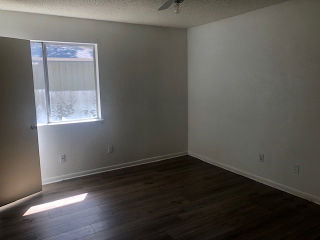 404 West Dittmar Road Austin, TX 78745 - Photo 13 of 15 Empty room featuring a textured ceiling, dark wood-style flooring, and a ceiling fan