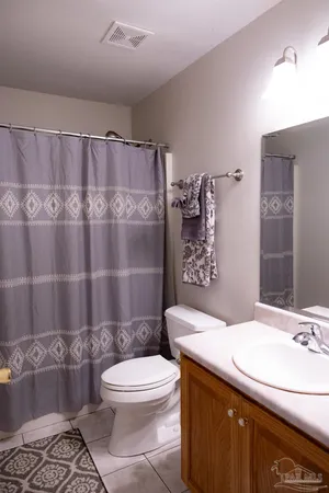 a bathroom with a sink a toilet and shower curtain