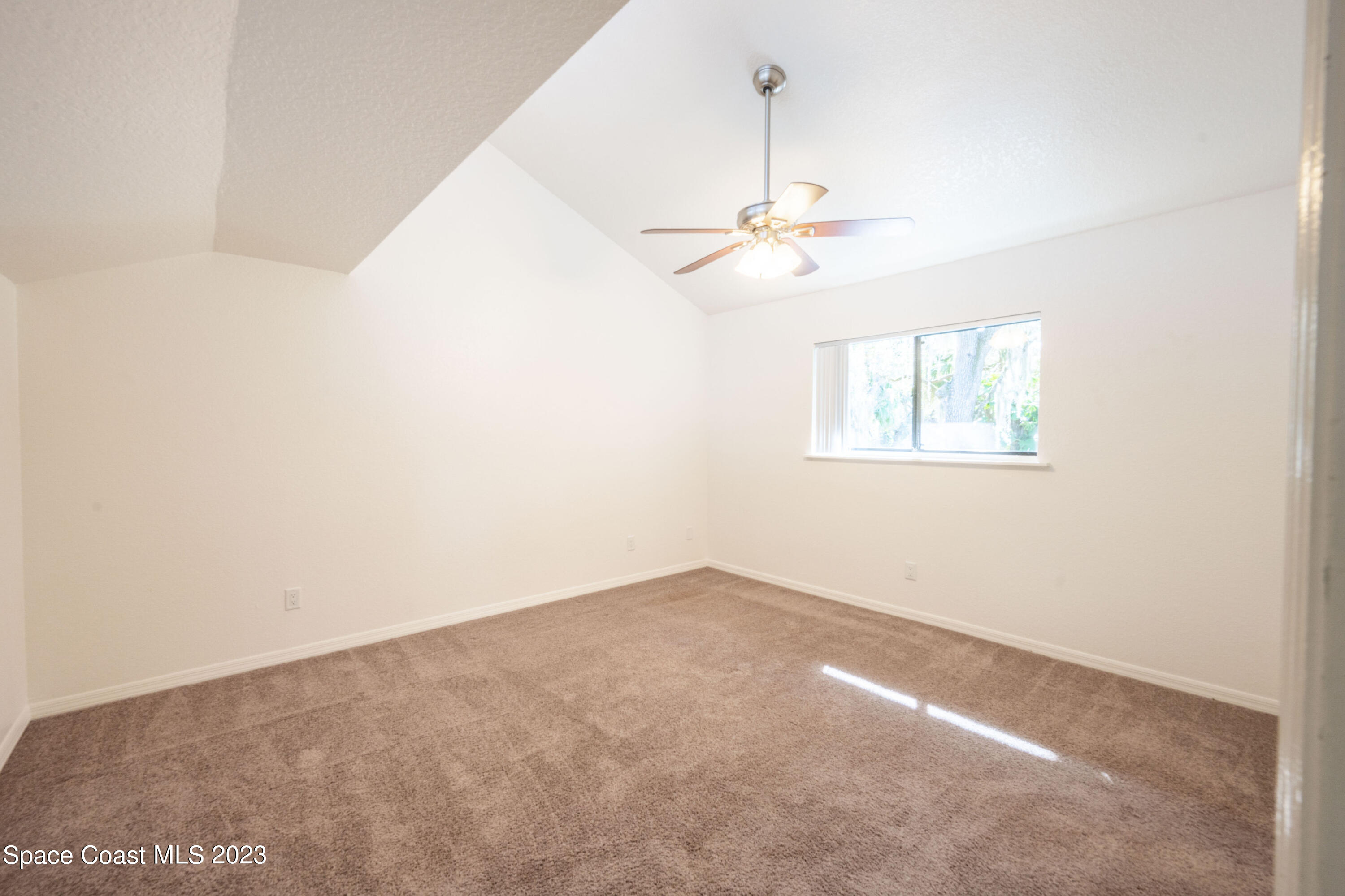 1130 Gary Hunt Road, Unit B Cocoa, FL 32926 - Photo 17 of 33 an empty room with a chandelier fan and windows