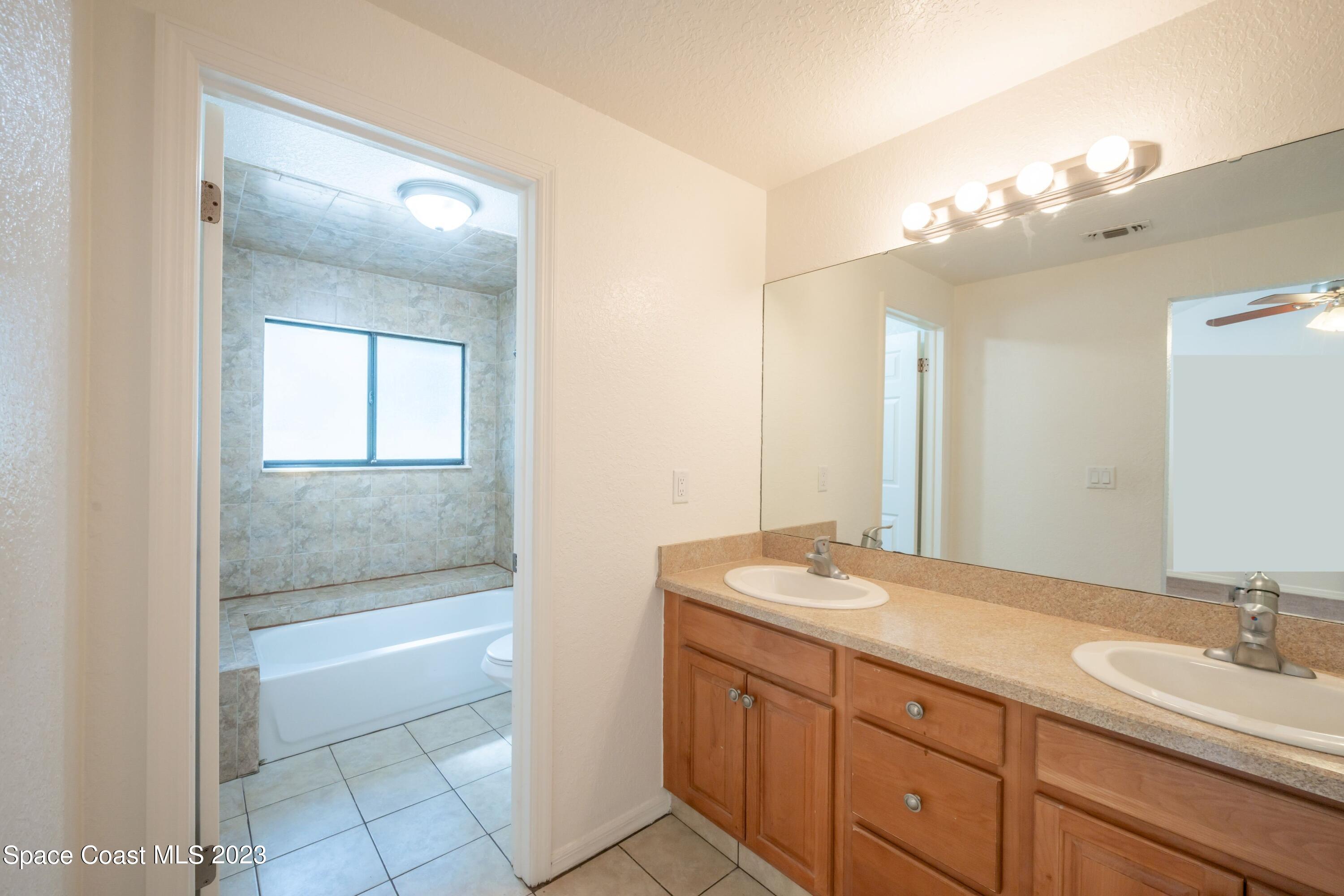 1130 Gary Hunt Road, Unit B Cocoa, FL 32926 - Photo 21 of 33 a bathroom with a sink a large mirror and a bathtub