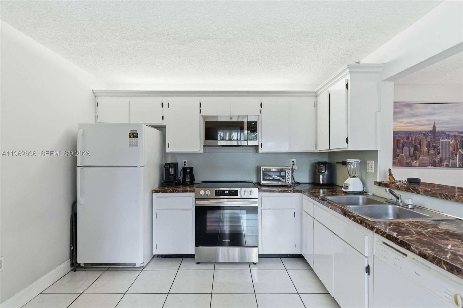 4726 Southwest 67th Avenue, Unit F6 Miami, FL 33155 - Photo 14 of 37 a kitchen with white cabinets and white appliances