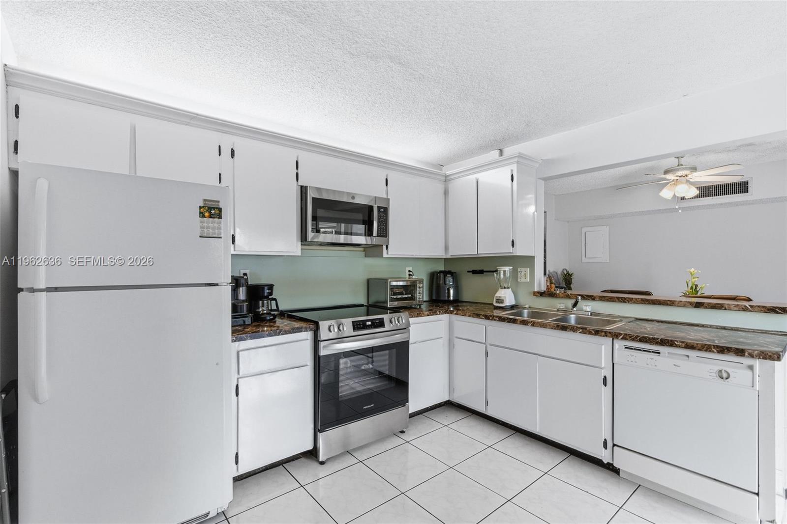 4726 Southwest 67th Avenue, Unit F6 Miami, FL 33155 - Photo 15 of 37 a kitchen with cabinets stainless steel appliances and a sink