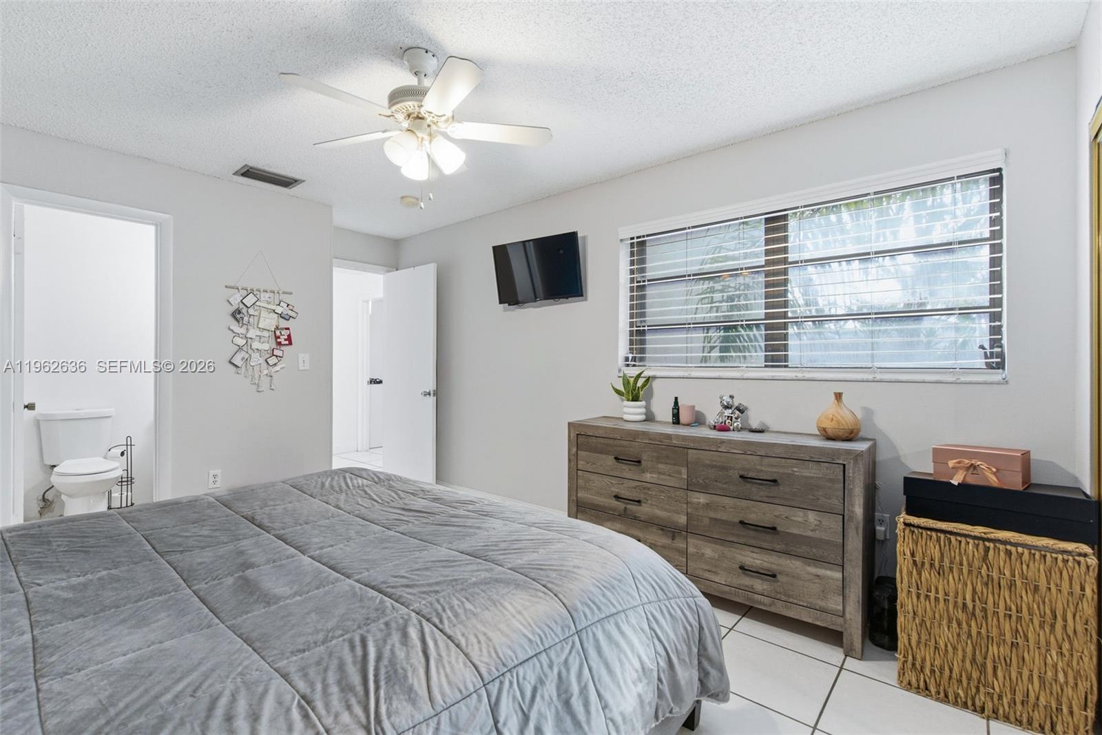 4726 Southwest 67th Avenue, Unit F6 Miami, FL 33155 - Photo 28 of 37 a bedroom with a large bed and a window