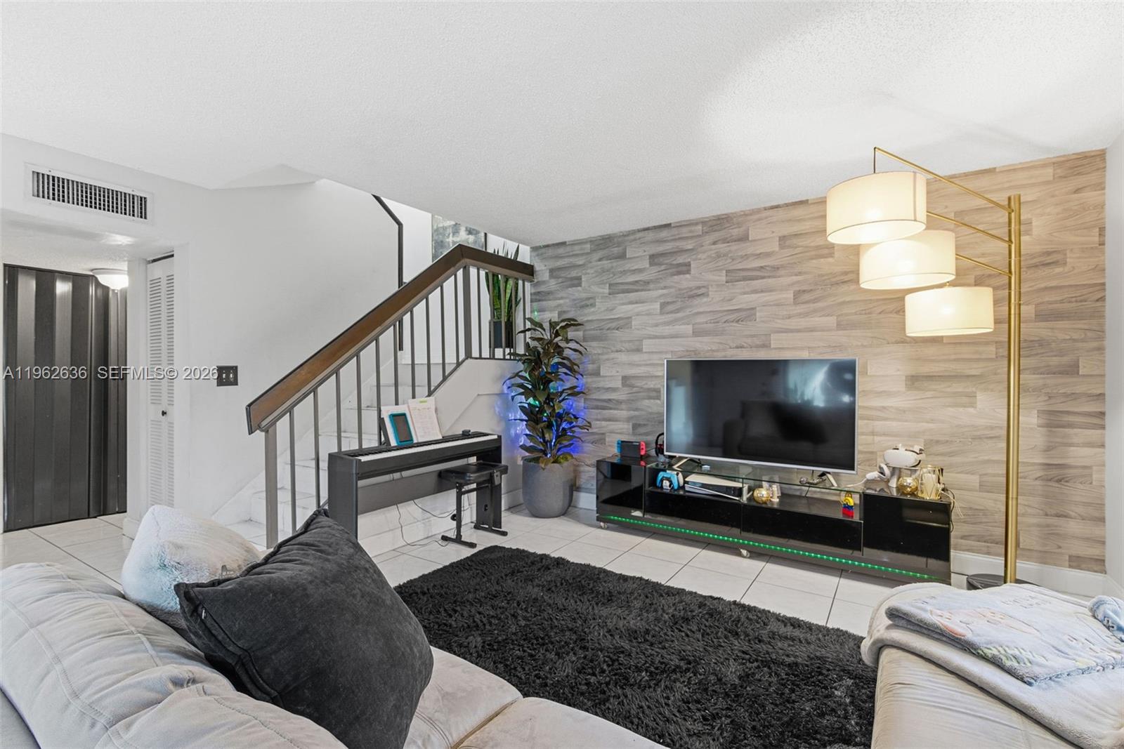 4726 Southwest 67th Avenue, Unit F6 Miami, FL 33155 - Photo 9 of 37 a living room with furniture and a flat screen tv