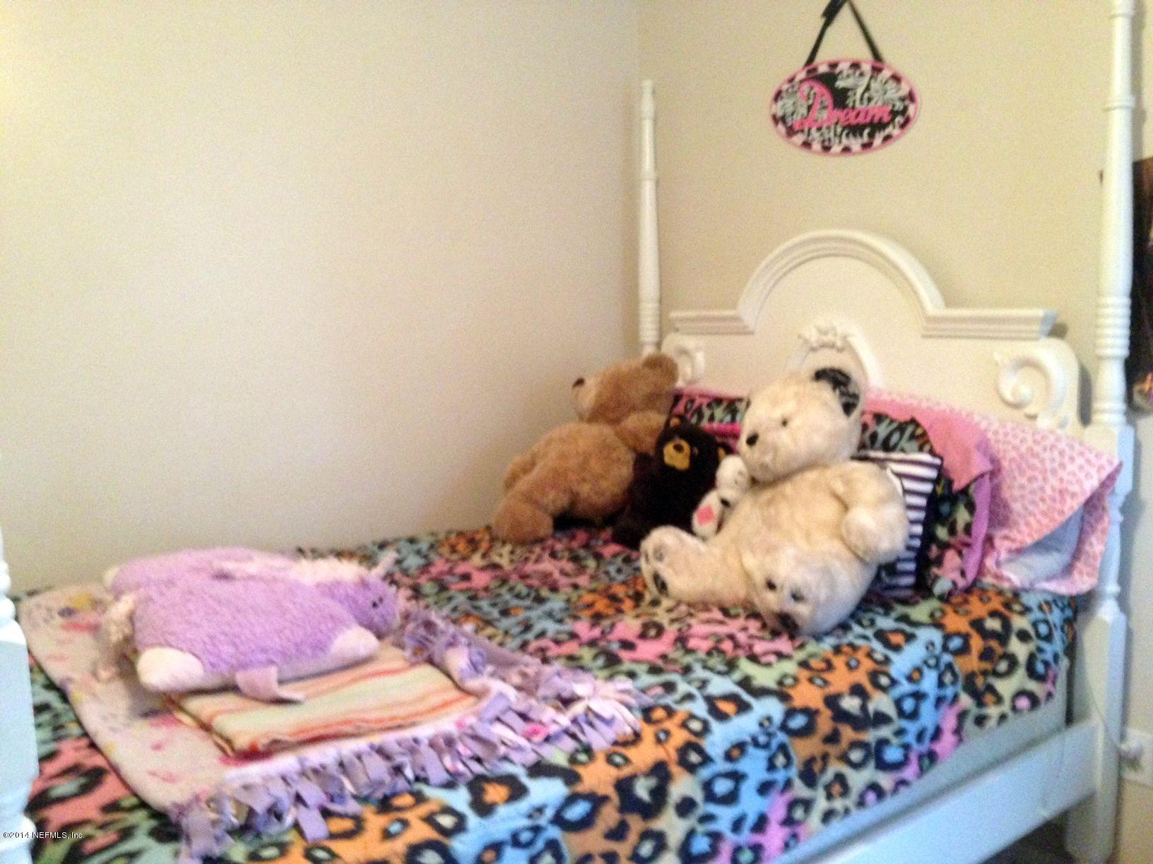 438 Federal Hill Road Orange Park, FL 32073 - Photo 12 of 14 a bedroom with a bed and a cabinets