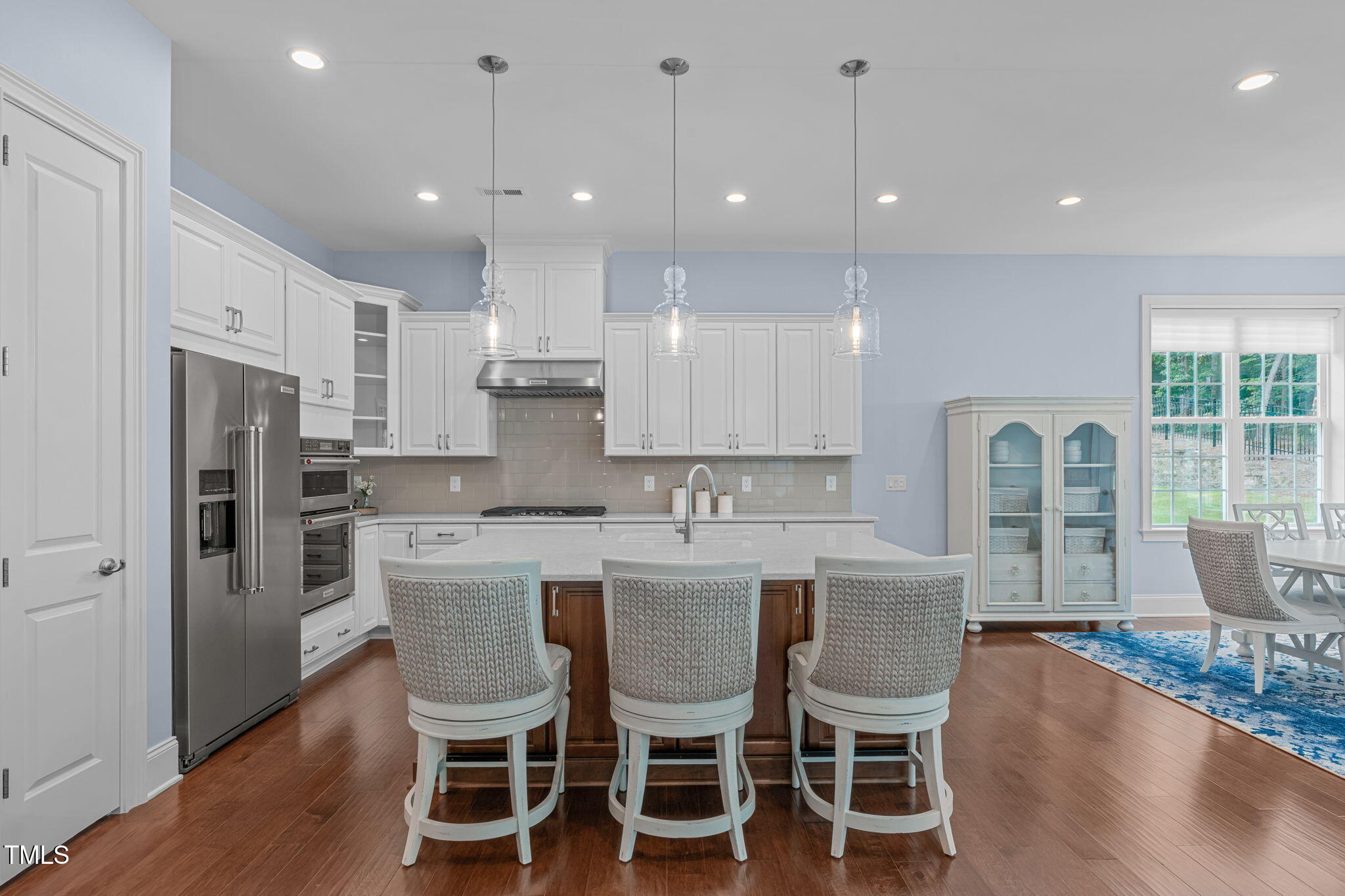 2511 Range Overlook Crossing Apex, NC 27523 - Photo 13 of 50 a dining room with stainless steel appliances kitchen island granite countertop a dining table chairs and a refrigerator