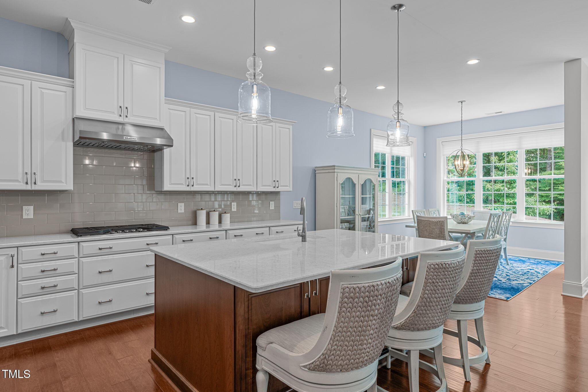 2511 Range Overlook Crossing Apex, NC 27523 - Photo 15 of 50 a kitchen with a stove a sink a dining table and chairs