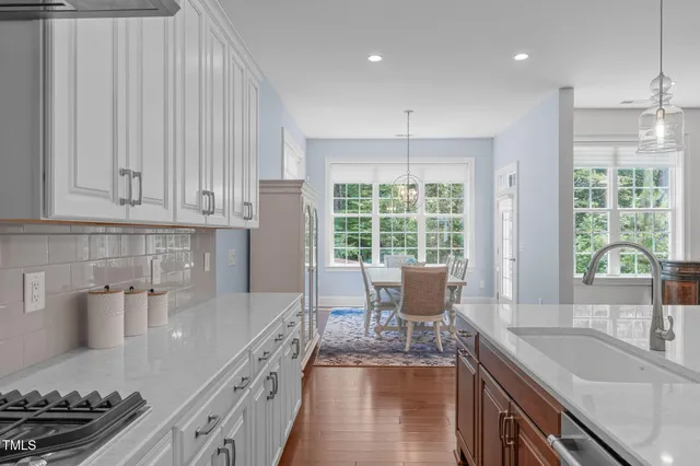 a kitchen with stainless steel appliances granite countertop a sink stove and cabinets
