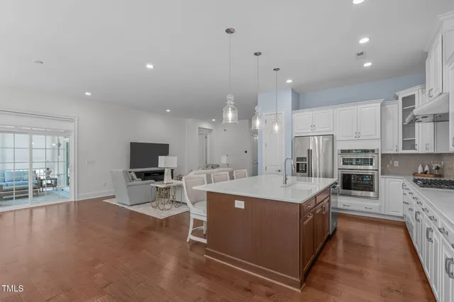 a large white kitchen with stainless steel appliances