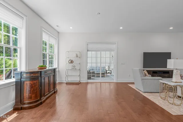 a living room with furniture a flat screen tv and large windows