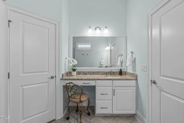 a spacious bathroom with a granite countertop sink a mirror and a