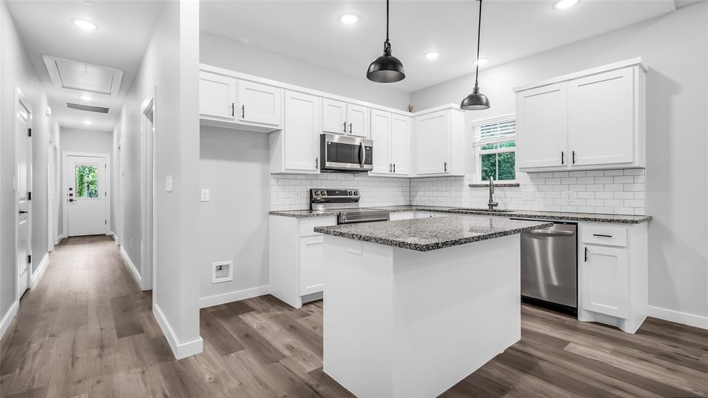 716 East Chestnut Street Denison, TX 75021 - Photo 6 of 26 Kitchen featuring white shaker cabinetry, stainless steel appliances, speckled stone countertops, and a subway tile backsplash