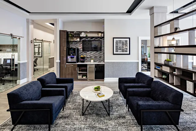 a living room with furniture a rug and a bookshelf