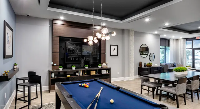 a room with furniture a chandelier and pool table