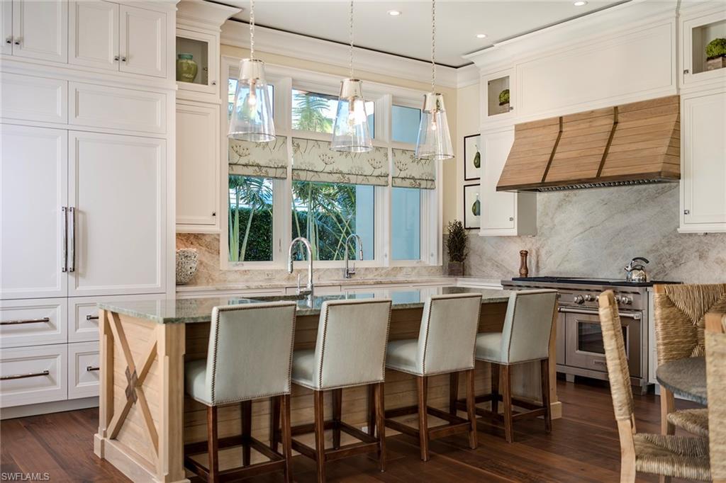 3450 Rum Row Naples, FL 34102 - Photo 15 of 25 a kitchen with a table chairs stove and cabinets