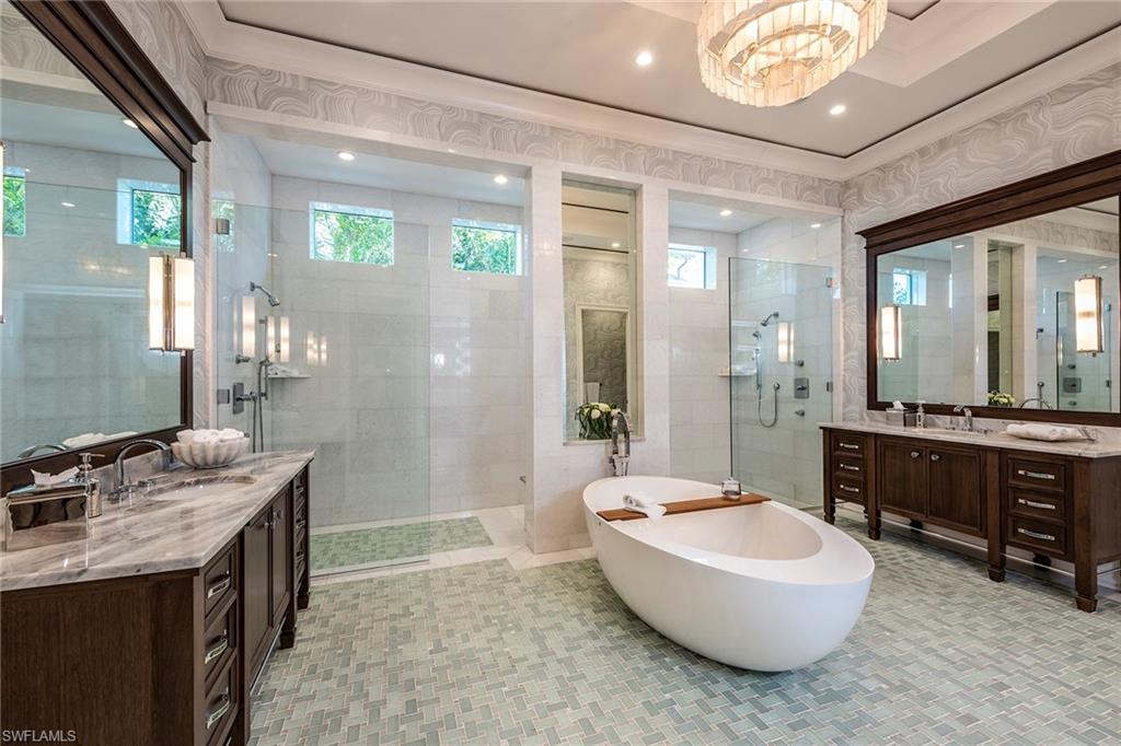 3450 Rum Row Naples, FL 34102 - Photo 22 of 25 a spacious bathroom with a tub sink shower and mirror