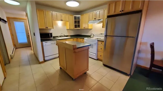 a kitchen with stainless steel appliances granite countertop a refrigerator a stove a sink and a refrigerator