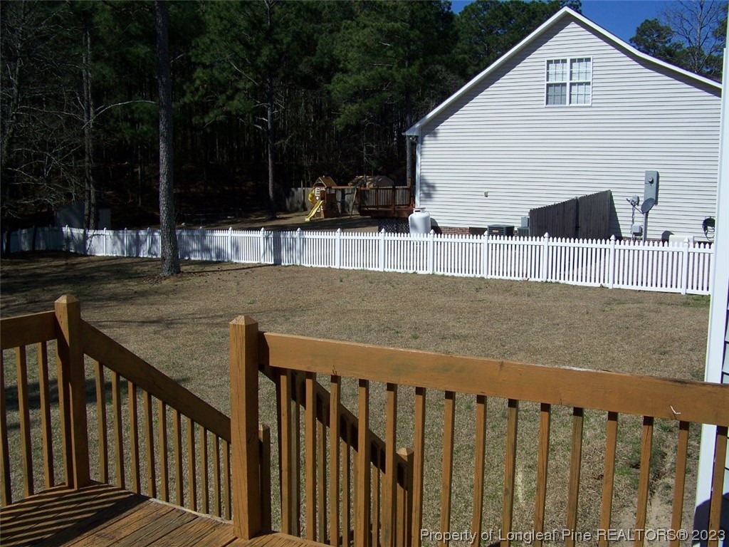 92 Cobblestone Drive Spring Lake, NC 28390 - Photo 19 of 24 a view of a deck with wooden floor and fence