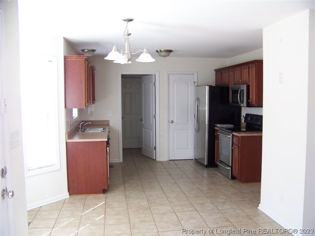 92 Cobblestone Drive Spring Lake, NC 28390 - Photo 8 of 24 a kitchen with granite countertop a refrigerator and a stove top oven