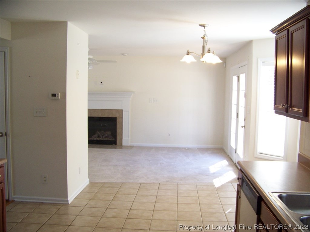 92 Cobblestone Drive Spring Lake, NC 28390 - Photo 9 of 24 an empty room with kitchen view and a fireplace