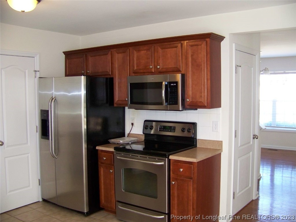 92 Cobblestone Drive Spring Lake, NC 28390 - Photo 10 of 24 a kitchen with stainless steel appliances granite countertop a refrigerator stove and microwave