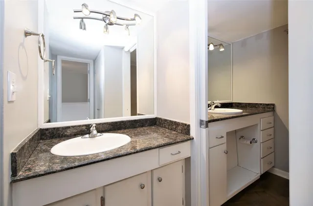 a bathroom with a granite countertop sink and a mirror