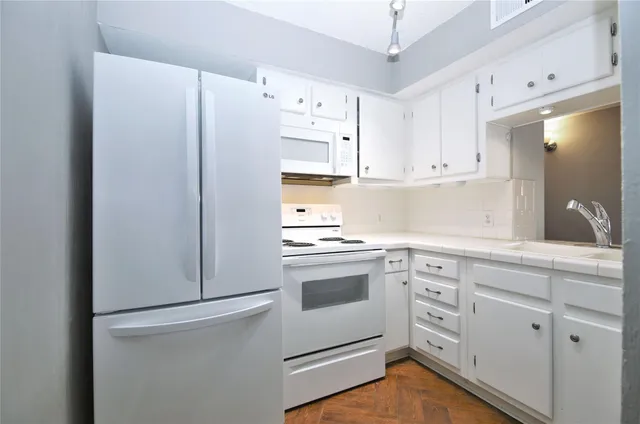 a kitchen with cabinets stainless steel appliances and a counter space