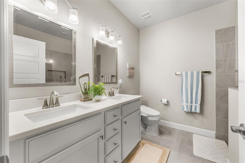 9437 Southwest 67th Lane Gainesville, FL 32608 - Photo 14 of 41 a bathroom with a double vanity sink toilet and a mirror
