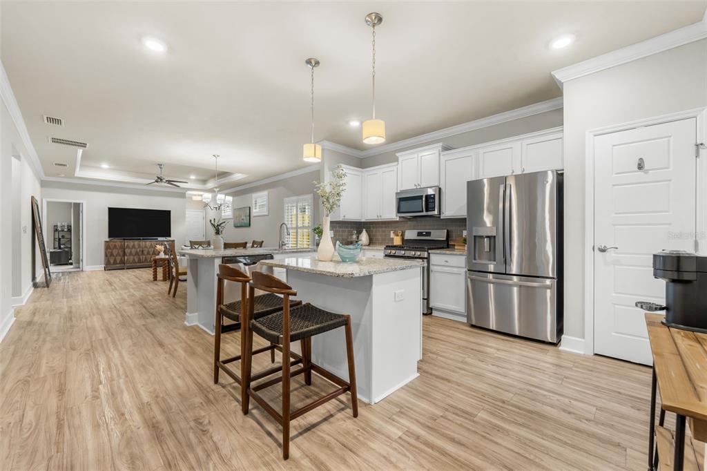 9437 Southwest 67th Lane Gainesville, FL 32608 - Photo 9 of 41 a kitchen with stainless steel appliances a refrigerator a stove top oven and a center island