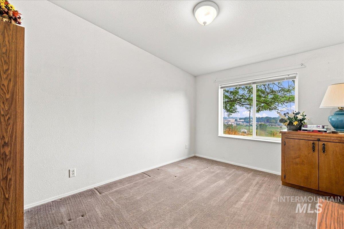 310 Frontage Road Grand View, ID 83624 - Photo 25 of 38 Room featuring a picture window, white textured walls, and a flush-mount ceiling light