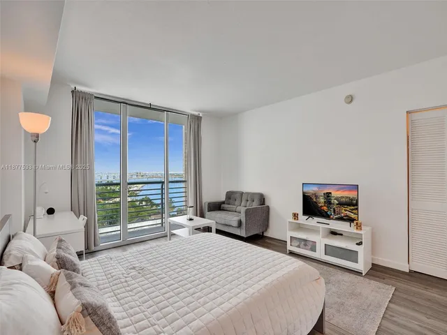 a bedroom with a bed and a flat screen tv