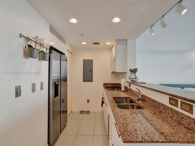 a kitchen with stainless steel appliances granite countertop a refrigerator a oven and a sink