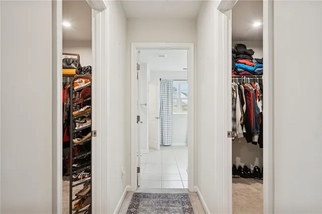 a view of a hallway with closet and a window