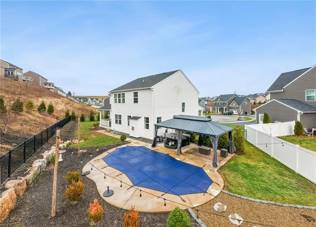 a view of a house with pool and chairs
