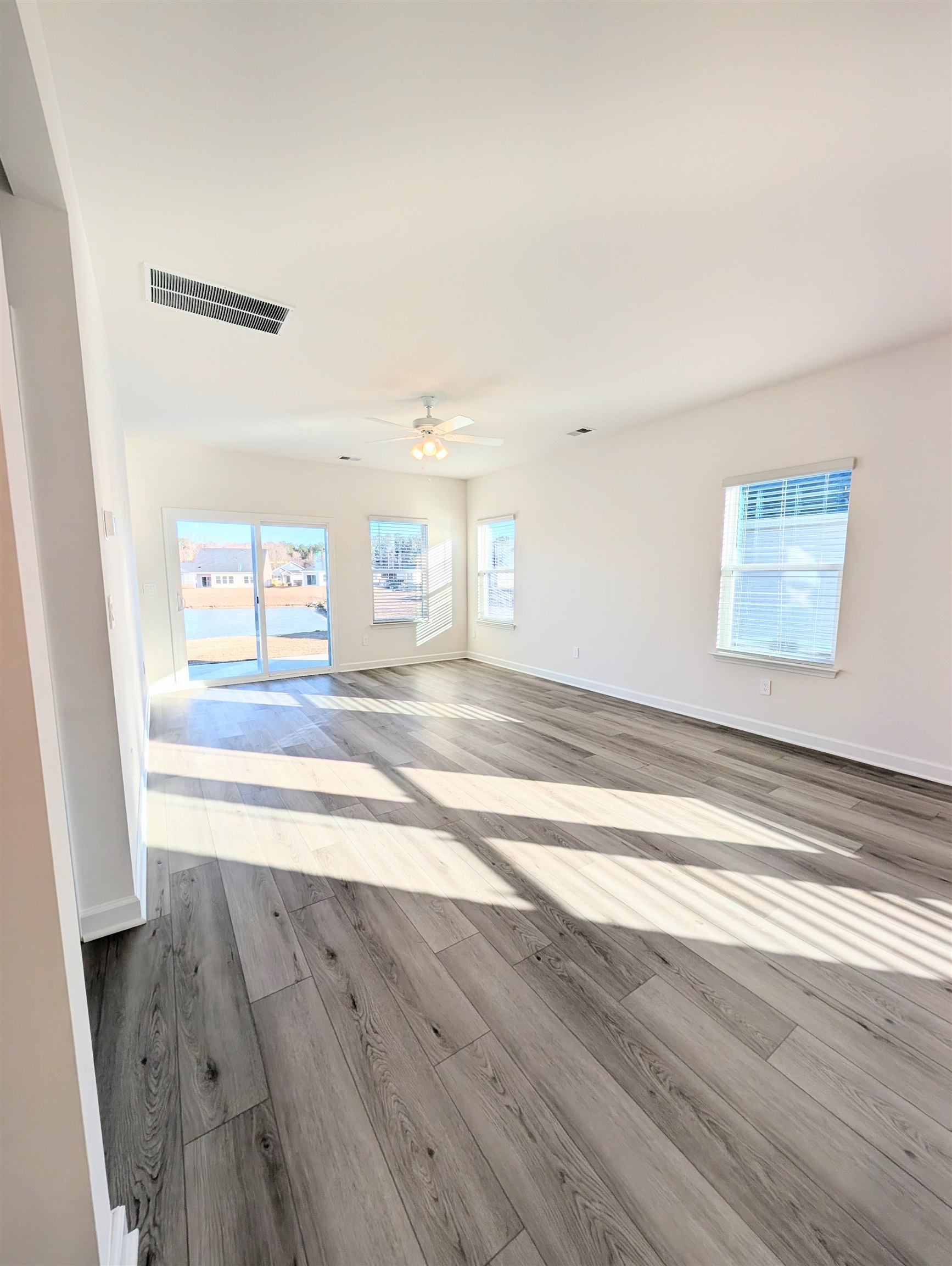 1508 Regal Fern Way Longs, SC 29568 - Photo 11 of 38 Unfurnished living room featuring light wood-style flooring and ceiling fan