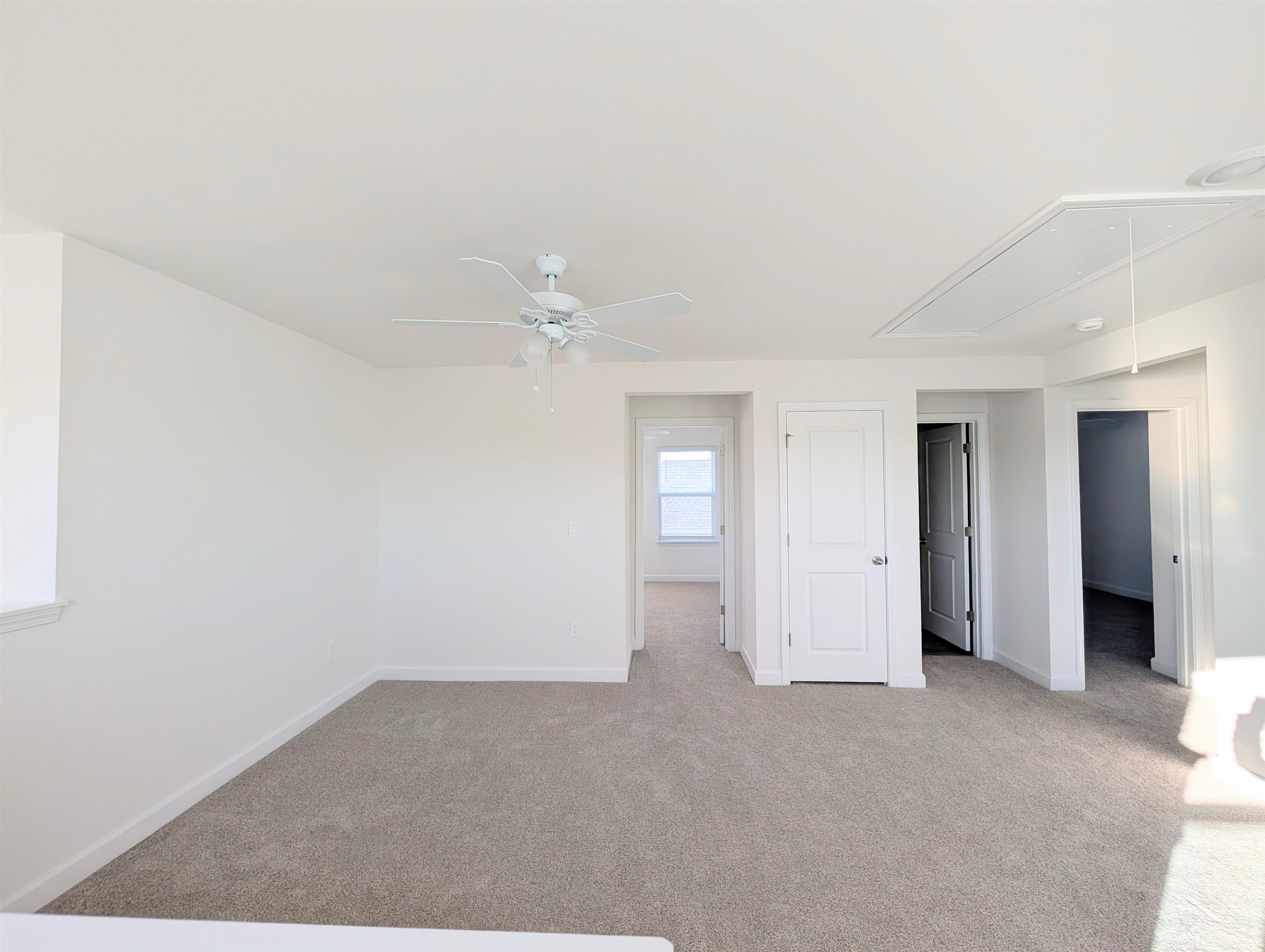 1508 Regal Fern Way Longs, SC 29568 - Photo 22 of 38 Unfurnished bedroom with attic access, light colored carpet, and a ceiling fan