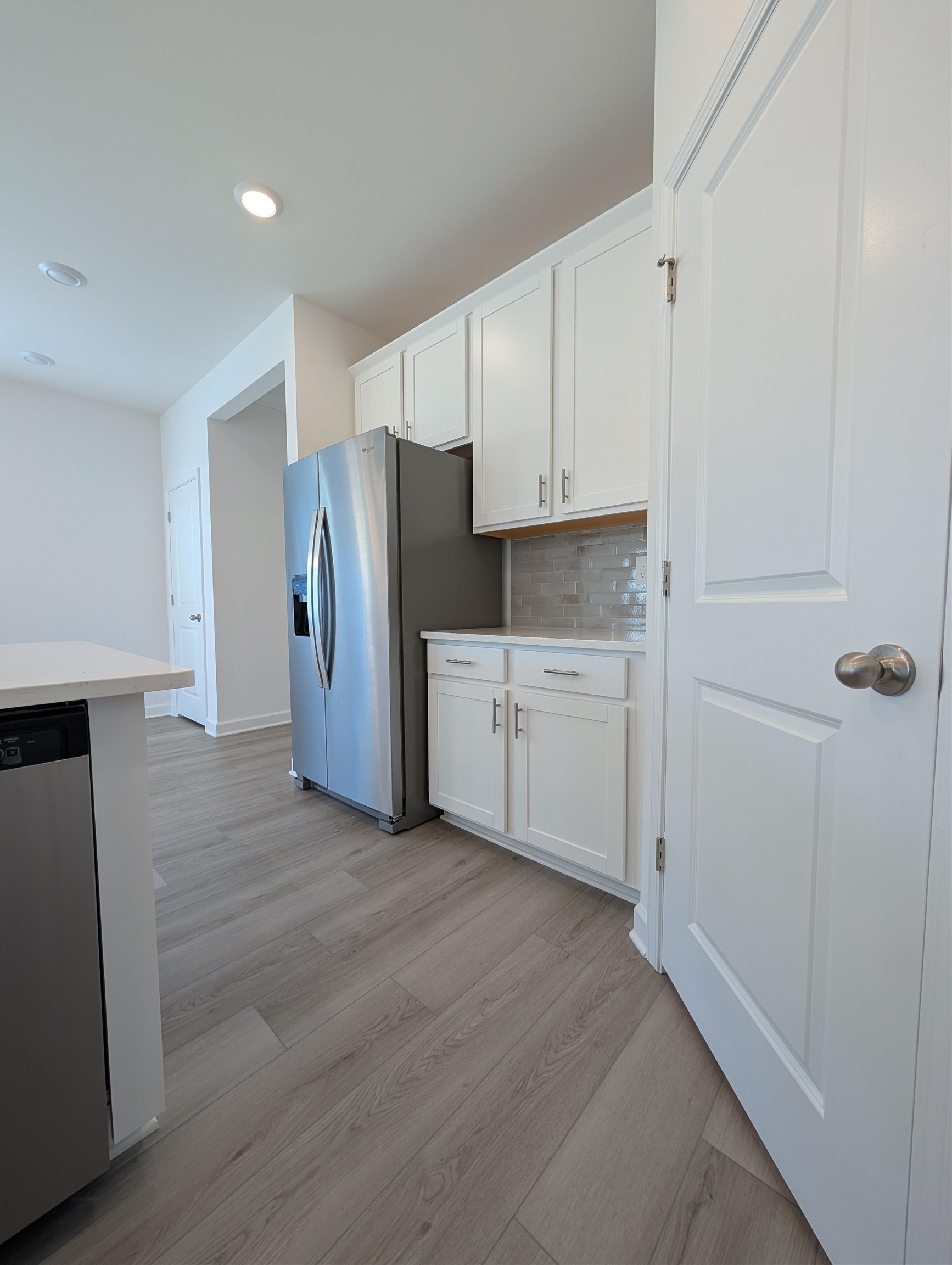 1508 Regal Fern Way Longs, SC 29568 - Photo 7 of 38 Kitchen featuring white cabinets, light countertops, appliances with stainless steel finishes, light wood-style floors, and decorative backsplash