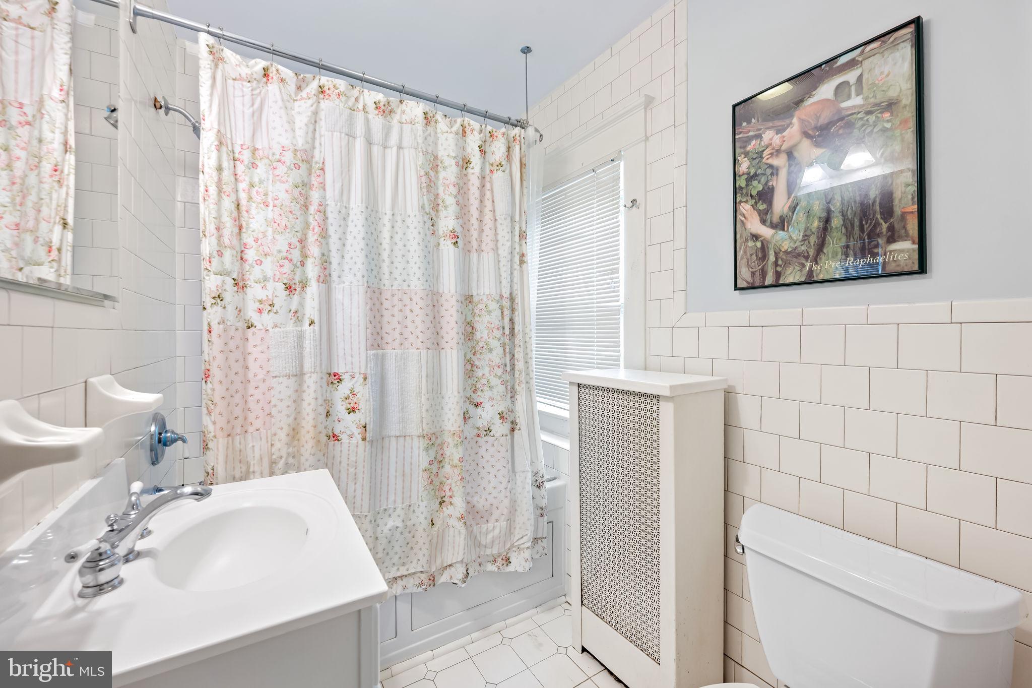 305 Tunbridge Road Baltimore, MD 21212 - Photo 32 of 58 a bathroom with a sink a toilet and shower curtain