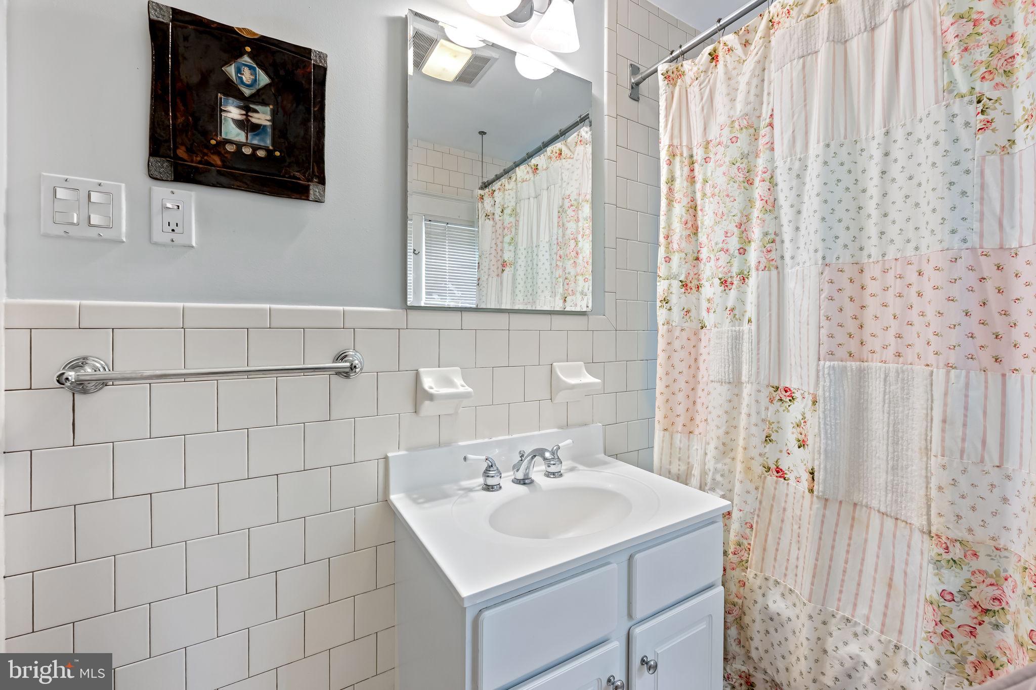 305 Tunbridge Road Baltimore, MD 21212 - Photo 33 of 58 a bathroom with a sink a vanity and a shower curtain